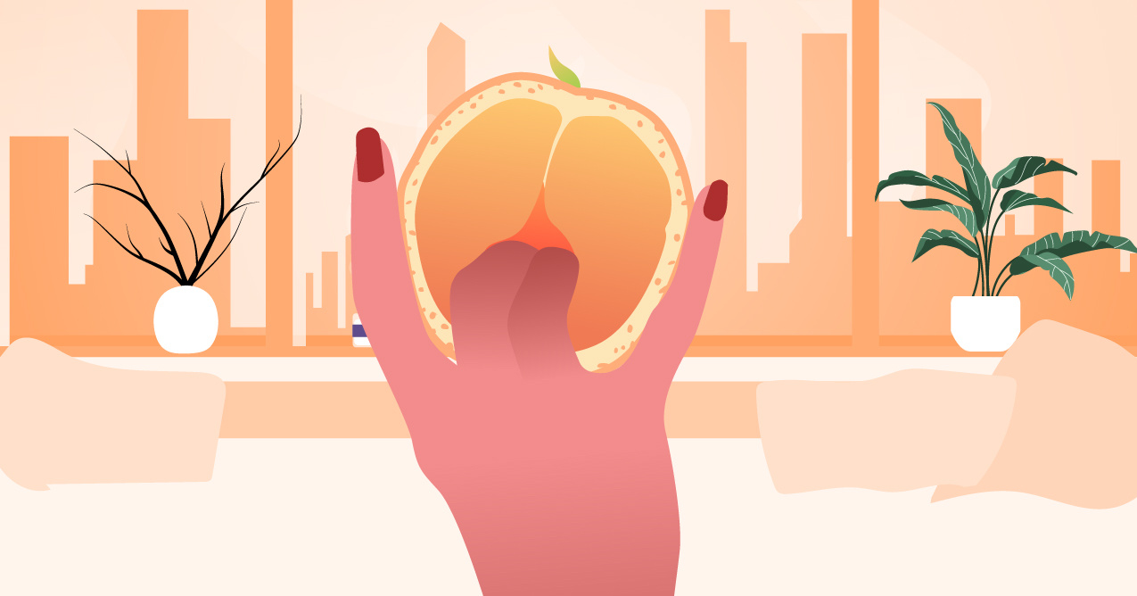 A person poking a grapefruit with their finger. 