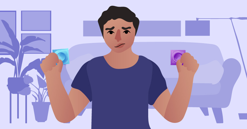 A worried guy holding condoms in both hands. 