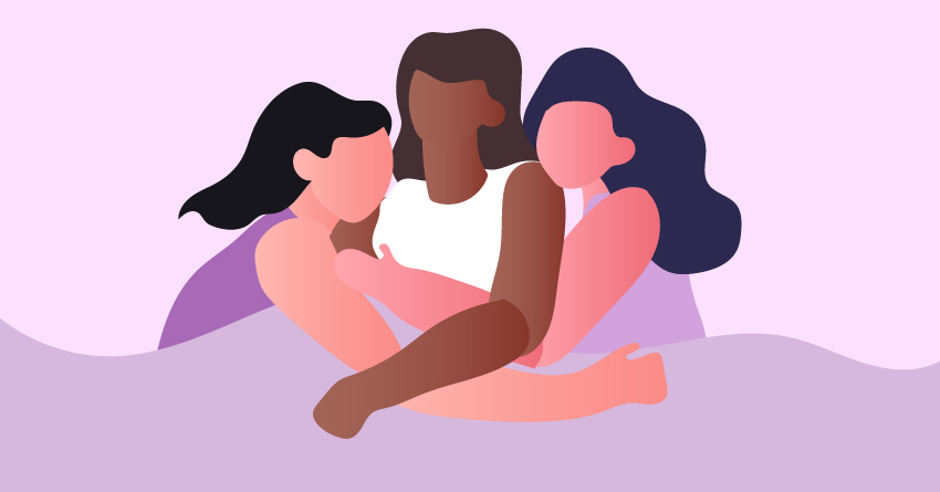 Three women cuddling in a bed. 