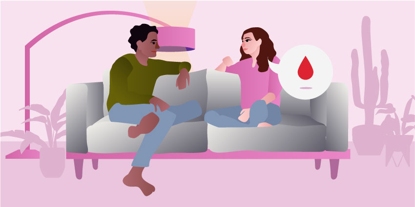 A couple sitting in a sofa and talking about period sex. 