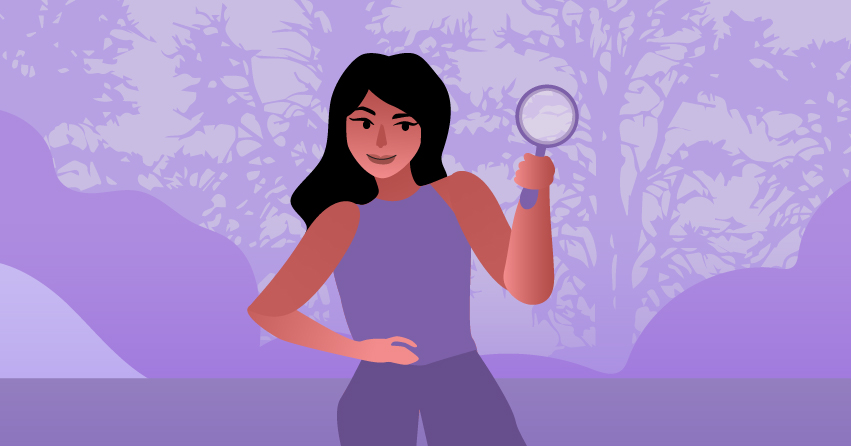 A woman holding a magnifying glass while exploring the forest. 