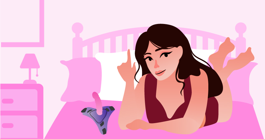 A woman lying in her bed, with a strap-on dildo next to her. 