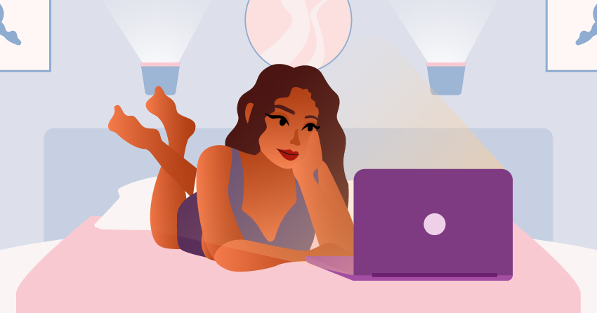 A woman watching something in the laptop, while lying down in her bed. 