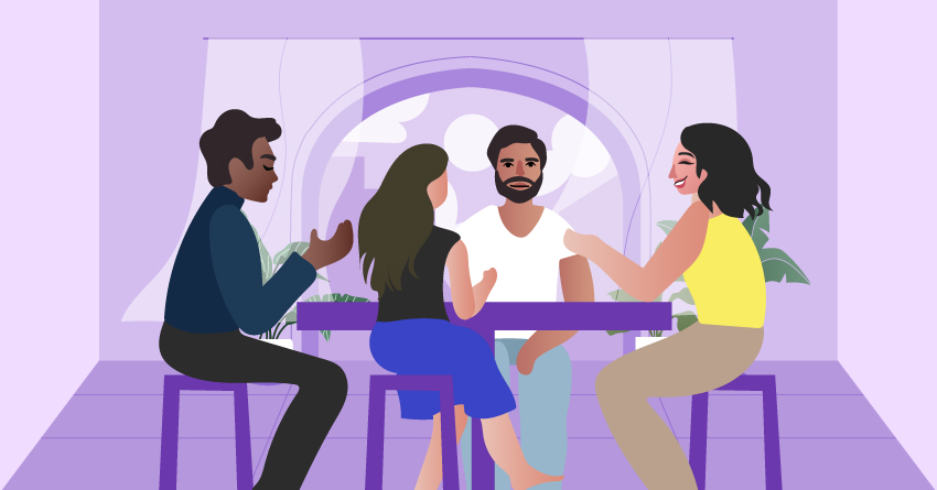 A group of non-binary people having a conversation while sitting in a dining area. 