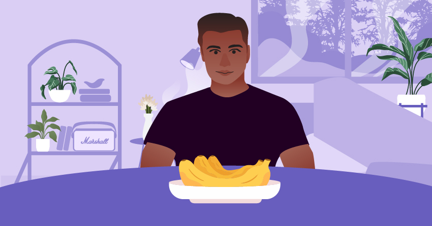 A man sitting in front of the dining table, with a plate of banana in front of him. 