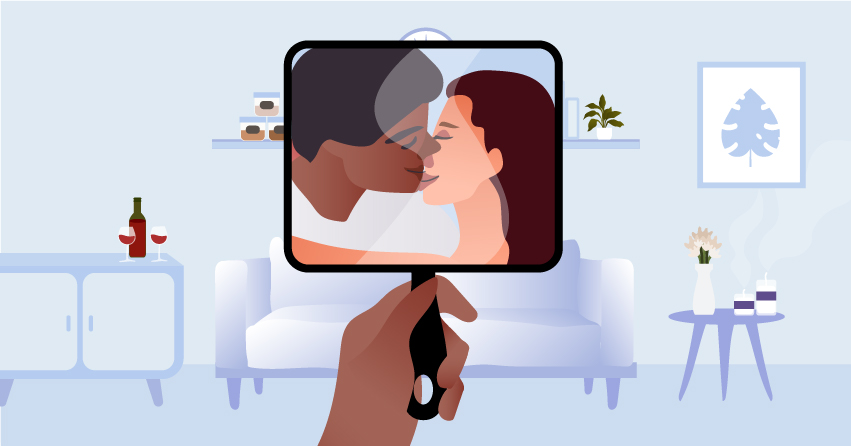 A handheld mirror showing reflection of a couple kissing. 