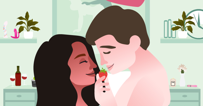 A couple leaning close to each other while the man is holding a strawberry. 