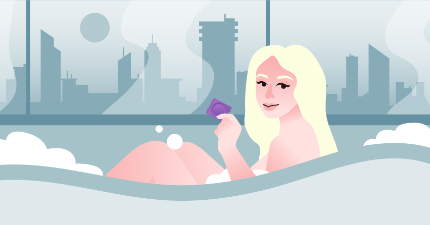 A woman sitting in the bathtub, holding a condom. 