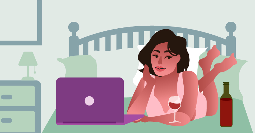 A woman watching a movie in her bed using her laptop, with a glass of wine and wine bottle next to it. 